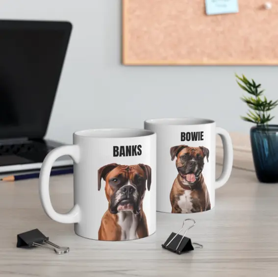 wo custom mugs on a desk, one with a boxer named BANKS and the other with a smaller dog named BOWIE.