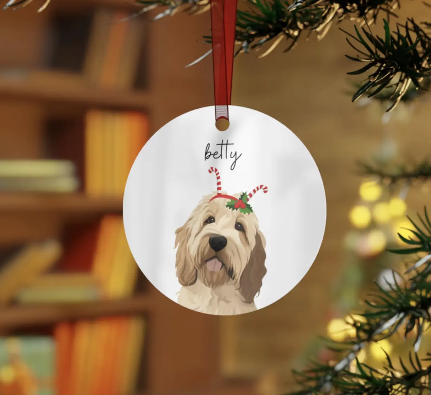 Personalized dog ornament with 'Betty' on it, hanging from a Christmas tree